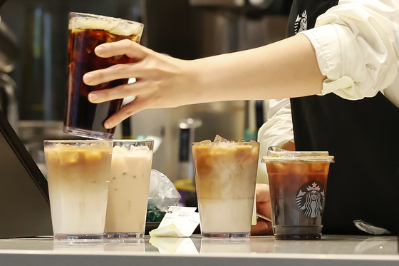 An employee at Starbucks makes coffee in a store in downtown Seoul on July 31. [NEWS1] 