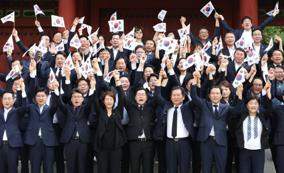 Democratic Party floor leader Park Chan-dae, center, and lawmakers hold the Korean flag up and shout "Manse" at Hyochang Park in Yongsan District, central Seoul, on Thursday, marking the country's 79th Liberation Day. [YONHAP]