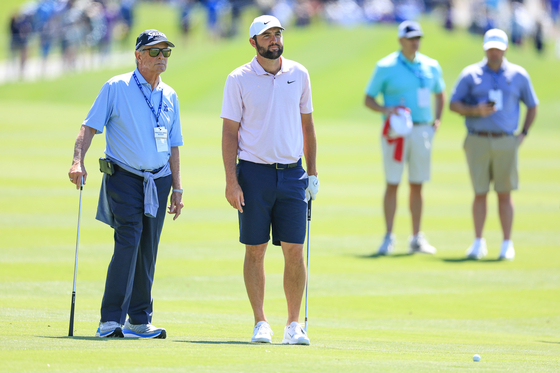 Scottie Scheffler waits with his coach Randy Smith on the 18th hole prior to The Players Championship on the Stadium Course at TPC Sawgrass on March 12 in Ponte Vedra Beach, Florida. [GETTY IMAGES]