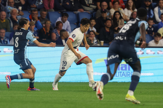 PSG's Lee Kang-in, center, in action against Yassine Kechta, left, of Le Havre during their match in Le Havre, France on Friday. [EPA/YONHAP]