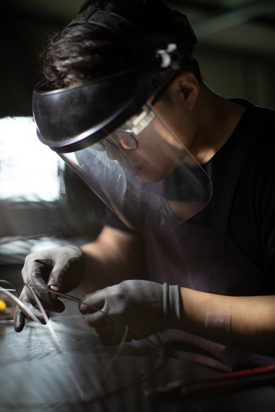 Cheon Woo-sun works on his wire vessels in his studio in Goyang, Gyeonggi (SOLUNA ART GROUP)