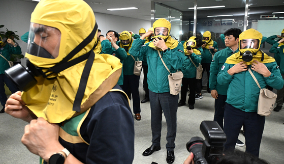 Seoul Mayor Oh Se-hoon, center, wears a gas mask during a CBRN defense drill at the City Hall in central Seoul on Monday. [SEOUL METROPOLITAN GOVERNMENT]