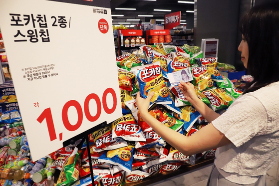 A customer picks a pack of Orion's Poca Chips, which sell for 1,000 won (75 cents). [ORION]