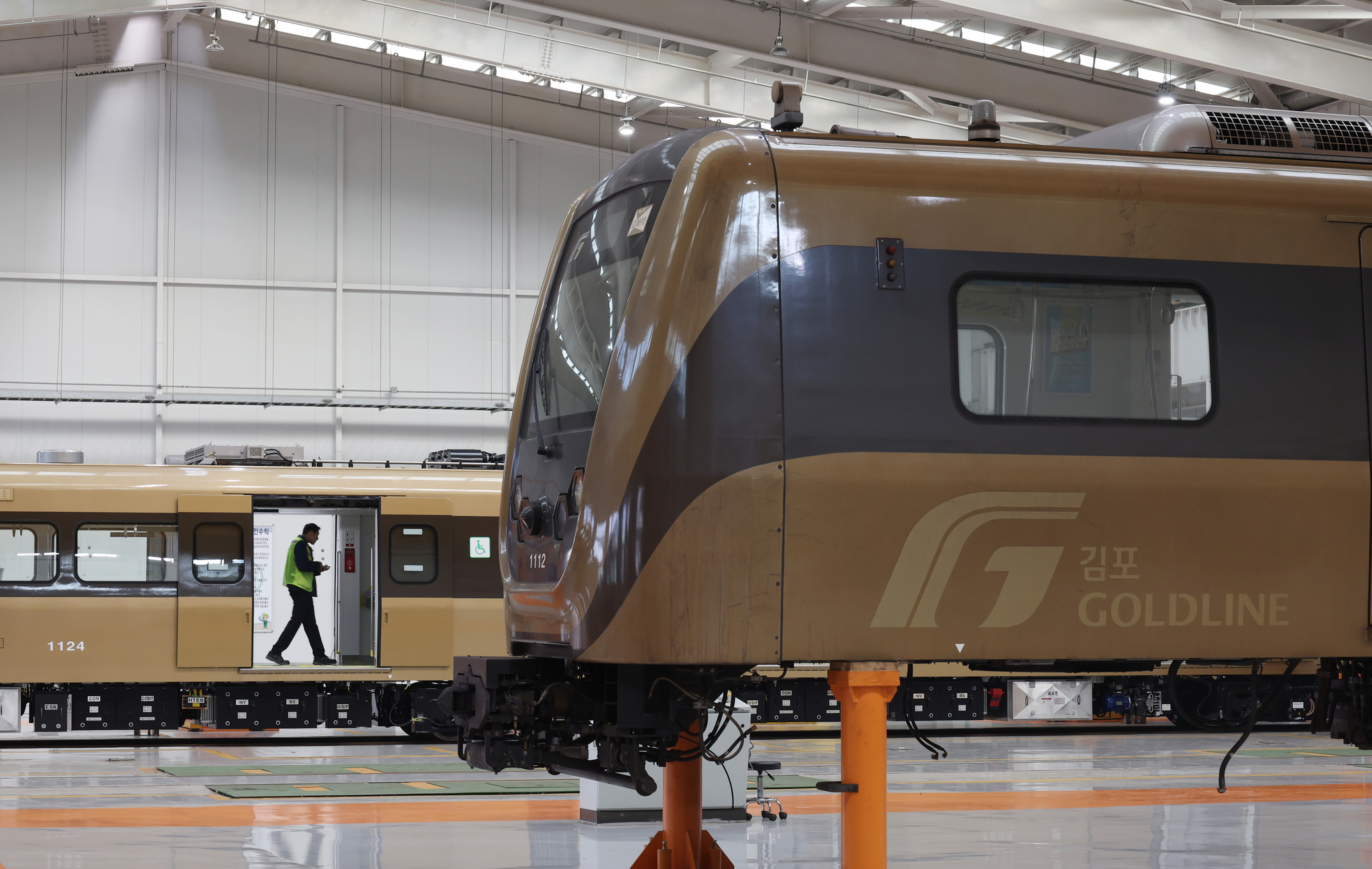 A mechanic inspects a Gimpo Goldline train at a railway depot in October 2023. [YONHAP]