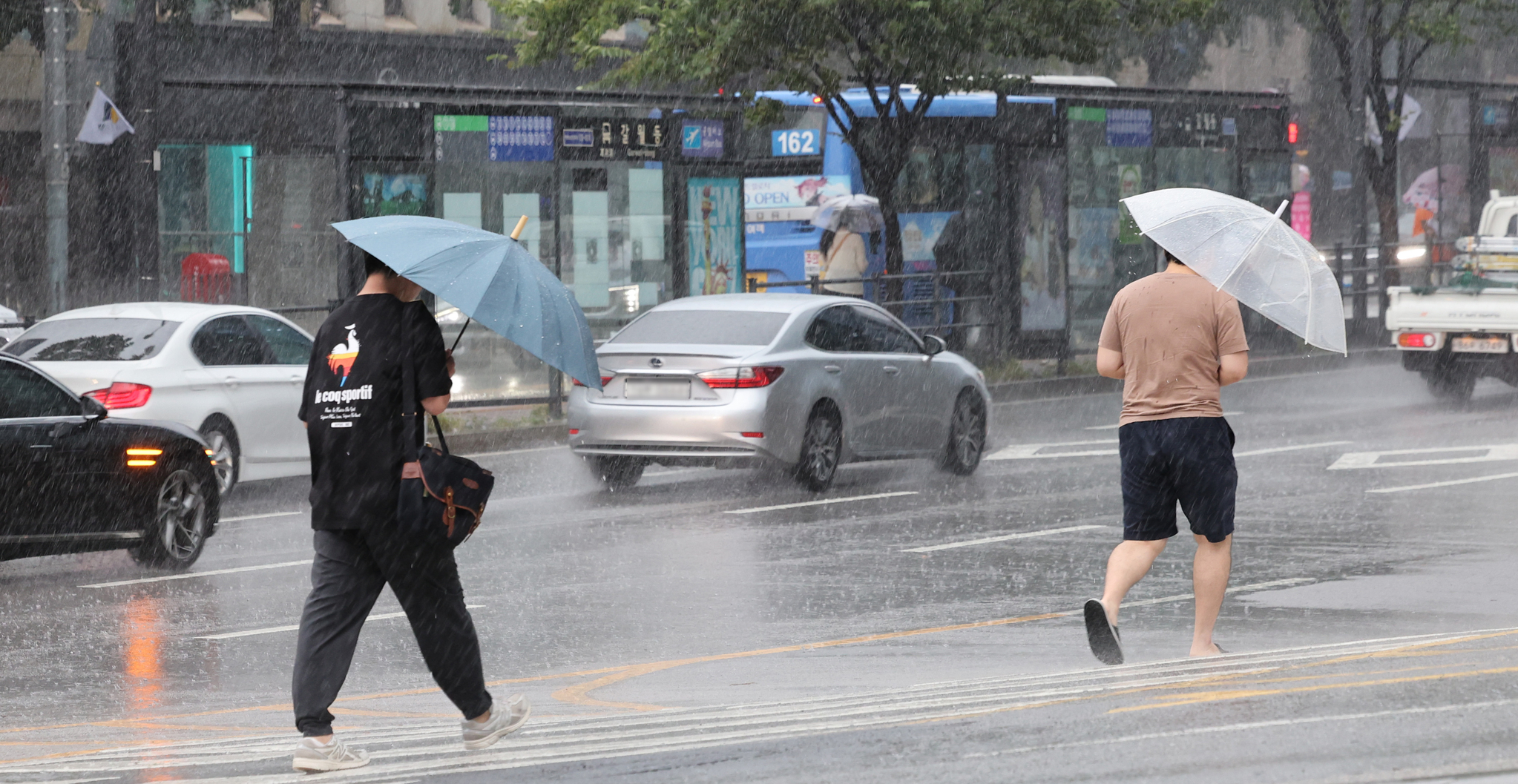 Citizens rush near Seoul Station in Yongsan District, central Seoul, on Wednesday morning as Typhoon Jongdari brings heavy rain and strong winds. [NEWS1]