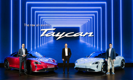 From left, Alexander Fabig, vice president of Individualization and Classic at Porsche AG, Porsche Korea CEO Holger Gerrmann and Kevin Giek, vice president of product line limousines at Porsche AG, pose with the new Taycan EV during a media event in central Seoul on Thursday. [PORSCHE KOREA]