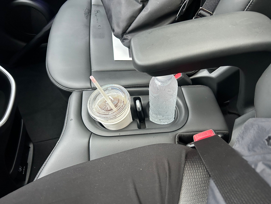 The gear knob has been changed to an electric shifter on the right side of the steering column, with cup holders in between the front seats. [SARAH CHEA]