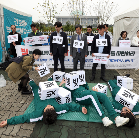 Small business owners protested against high interest rates and soaring debt near the National Assembly building in Yeouido, western Seoul. [YONHAP]