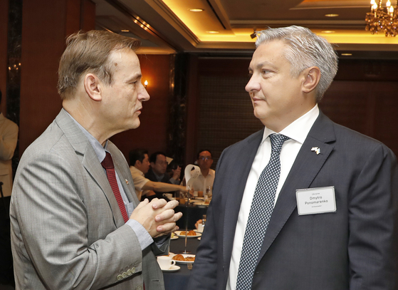 Ambassador of Germany Georg Schmidt, left, and Ambassador of Ukraine Dmytro Ponomarenko, exchange greetings during the 18th Korea Economic Forum at Lotte Hotel in Jung District, central Seoul, on Thursday. [PARK SANG-MOON]