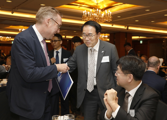 From left, Ambassador of the United Kingdom Colin Crooks, Chairman of the Korea Federation of Banks Cho Yong-byoung and Director of National Policy at the presidential office Sung Tae-yoon exchange greetings during the 18th Korea Economic Forum at Lotte Hotel in Jung District, central Seoul, on Thursday. [PARK SANG-MOON]