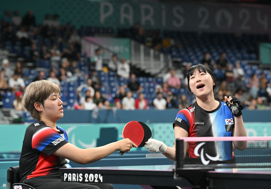 Korean table tennis players Yoon Ji-yu, left, and Seo Su-yeon compete in the women's doubles WD5 final against China at the 2024 Paris Paralympic Games in Paris on Friday. [YONHAP]