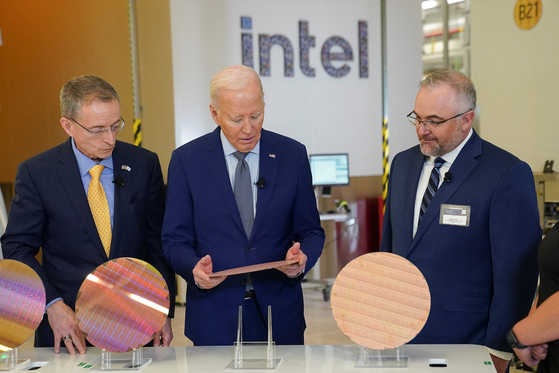 U.S. President Joe Biden looks at a wafer, as he tours the Intel ...