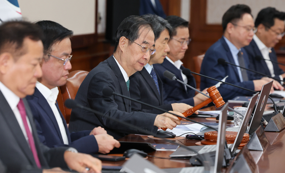 Prime Minister Han Duck-soo strikes the gavel to begin a Cabinet meeting at the government complex in central Seoul on Tuesday. [NEWS1]