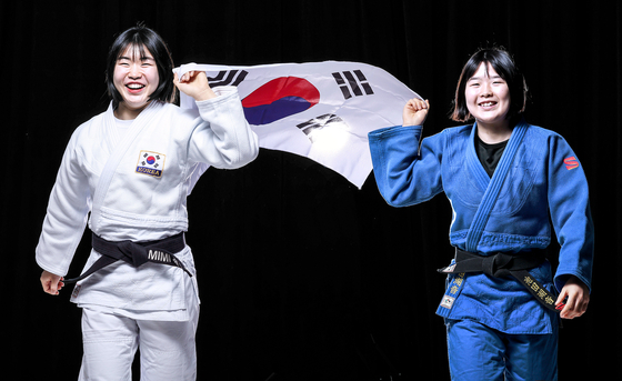 Judokas Huh Mi-mi, left, and Huh Mi-o pose with the Korean flag during an interview with the JoongAng Ilbo at the JoongAng Building in western Seoul on Feb. 15. [JOONGANG ILBO] 