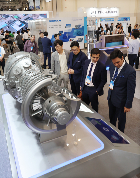 Attendees of the 2024 World Climate Industry Expo (WCE) observe a model of a gas turbine made by Doosan for use in aviation and power generation on Wednesday. [YONHAP]