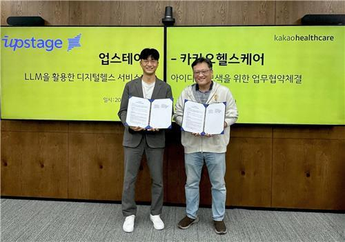 Upstage Chief Technology Officer Lee Hwal-suk, left, and Kakao Healthcare's head of research, Shin Soo-yong, pose for a photo at an MOU signing ceremony at Kakao Healthcare's headquarters in Pangyo, Gyeonggi.