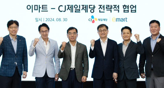 CJ CheilJedang co-CEO Kang Shin-ho, third from left, Emart CEO Han Chae-yang, fourth from left, and other executives pose for a group photo at a meeting to discuss their companies' collaborative efforts. [CJ CHEILJEDANG]