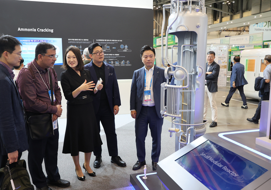 Attendees of the 2024 World Climate Industry Expo (WCE) observe a model of a small modular reactor made by Doosan for use in aviation and power generation on Wednesday. [YONHAP]