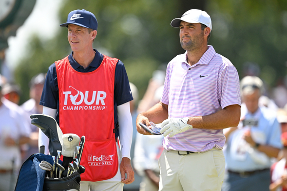 Scottie Scheffler talks with caddie, Ted Scott, on the first tee box during the first round of the Tour Championship at East Lake Golf Club in Atlanta, Georgia on Aug. 29.  [GETTY IMAGES]