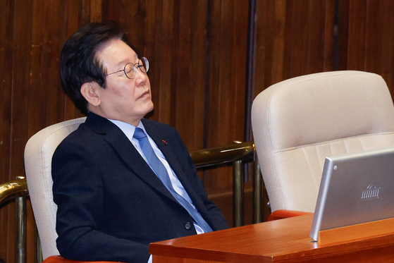 Democratic Party leader Lee Jae-myung listens to People Power Party floor leader Choo Kyung-ho's speech at the National Assembly in Yeouido, western Seoul, on Thursday. [NEWS1]