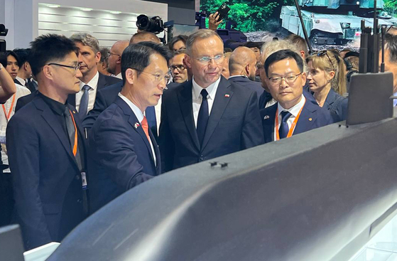 Polish President Andrzej Sebastian Duda (second from right) visits Hanwha's exhibition booth at this year's International Defence Industry Exhibition in Kielce, Poland. The president is accompanied by Hanwha Ocean Vice President Jeong Seung-kyun (second from left) and Hanwha Aerospace CEO Son Jae-il (first from right). [HANWHA OCEAN]