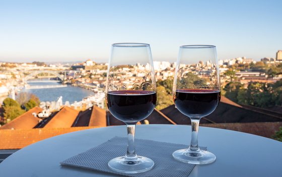 Port wines in glasses with view of the Douro River in the city of Porto, Portugal [LOTTE TOUR]