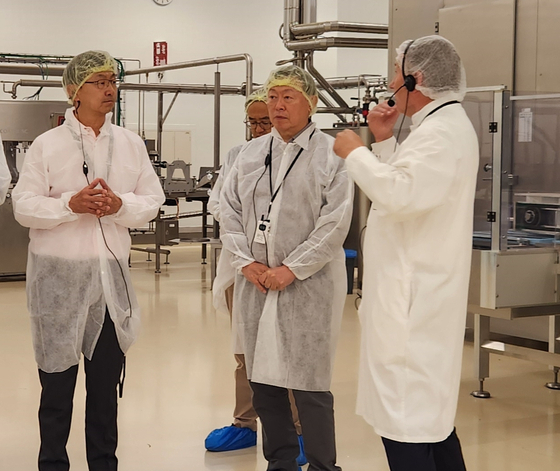 Lotte Chairman Shin Dong-bin, center, tours Guylian's chocolate manufacturing plant in Sint-Niklaas, Belgium. [LOTTE] 