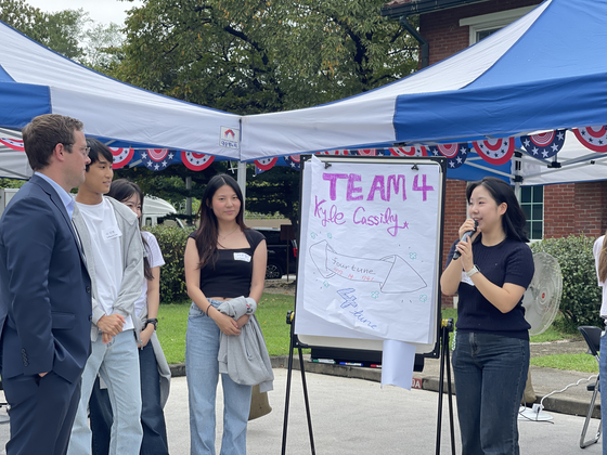 A diplomat from the U.S. Embassy in Seoul and members of the third cohort of the American Diplomacy House Academy present their team names during a kick-off ceremony in Yongsan District, central Seoul, on Friday. [LEE SOO-JUNG]