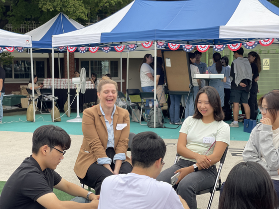 A diplomat from the U.S. Embassy in Seoul and members of the third cohort of the American Diplomacy House Academy talk during a kick-off ceremony in Yongsan District, central Seoul, on Friday. [LEE SOO-JUNG]