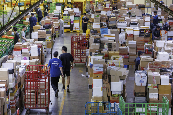 Workers sort parcels at the East Seoul Post and Logistics Center in Gwangjin District, eastern Seoul, on Tuesday, a week before the Chuseok harvest festival holiday. [YONHAP]