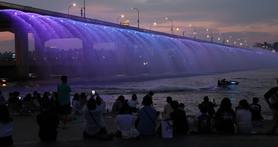 People watch the water fountains from Banpo Bridge on Aug. 15. [YONHAP] 