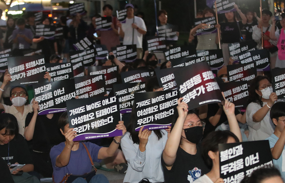 Participants hold up signs during a rally against deepfake pornography held near Bosingak Bell Pavilion in Jongno District, central Seoul, on Friday. [NEWS1]