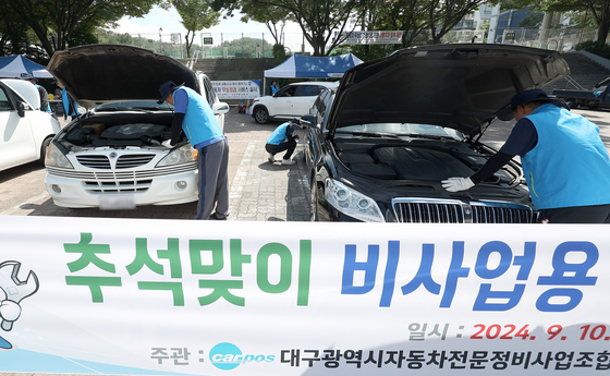 Technicians inspect cars in the parking lot of Daegu's Suseong-gu Sports Center on Tuesday as part of a free car inspection event ahead of the Chuseok harvest festival. [YONHAP]