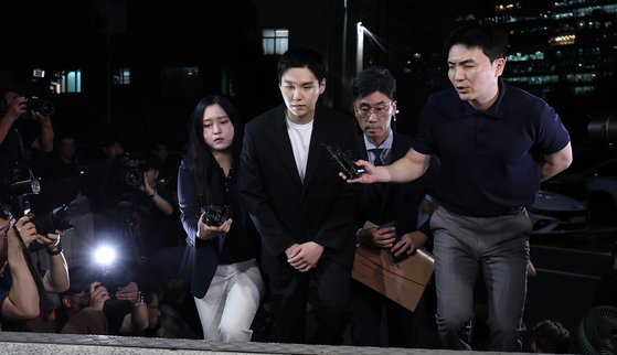 Suga is asked questions by reporters after arriving at the Yongsan Police Station to be questioned over this alleged DUI case on Aug. 23 in central Seoul. [NEWS1]