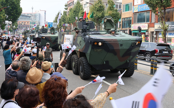 People wave the Korean national flag, taegeukgi, and greet armored vehicles near Dongincheon Station in Jung District, Incheon, during a parade held on Wednesday to commemorate the 74th anniversary of the Incheon landing. [YONHAP]