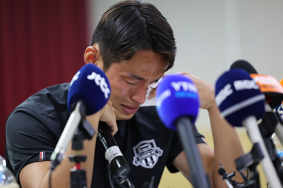 Suwon FC midfielder Son Jun-ho wipes away tears during a press conference at Suwon City Sports Council in Suwon, Gyeonggi on Wednesday. [YONHAP]