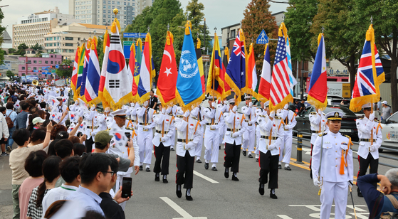 South Korean Navy officers and sailors hold the flags of the 23 nations that fought under the United Nations Command during the 1950-53 Korean War as they march down a street in Jung District, central Incheon, as part of a parade to commemorate the success of Operation Chromite on Sept. 15, 2023. [YONHAP]