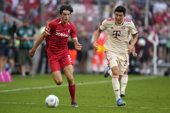 Freiburg's Merlin Roehl, left, and Bayern Munich's Kim Min-jae vie for the ball during aBundesliga match at the Allianz Arena in Munich, Germany on Sept. 1. [AP/YONHAP]