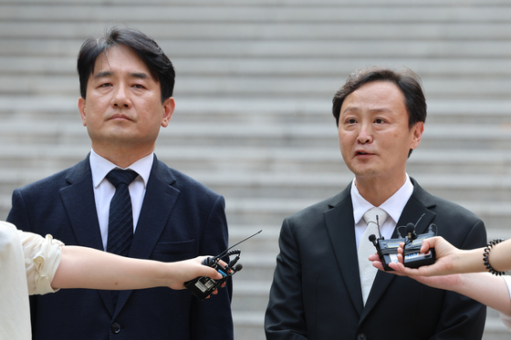 TMON CEO Ryu Gwang-jin, right, talks to reporters in front of the Seoul Bankrupty Court in southern Seoul on Tuesday after the court gave Qoo-10 owned e-commerce platforms TMON and WeMakePrice the green light to proceed with corporate rehabilitation. [YONHAP]