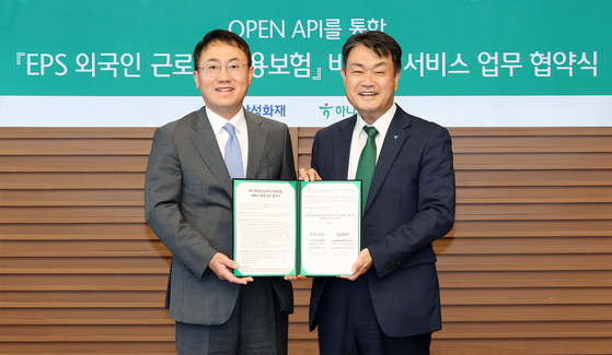 Samsung Fire & Marine Insurance Vice President Choi Jae-bong, let, and Hana Bank Deputy President Sung Young-su pose for a photo during a signing ceremony held at the Hana Bank headquarters in central Seoul on Wednesday. [HANA FINANCIAL GROUP]