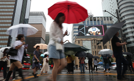 Citizens walk with umbrellas in Gwanghwamun in central Seoul on Thursday morning. [NEWS1]