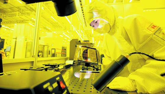 A Samsung Electronics engineer checks photomasks at a chip factory. [SAMSUNG ELECTRONICS]