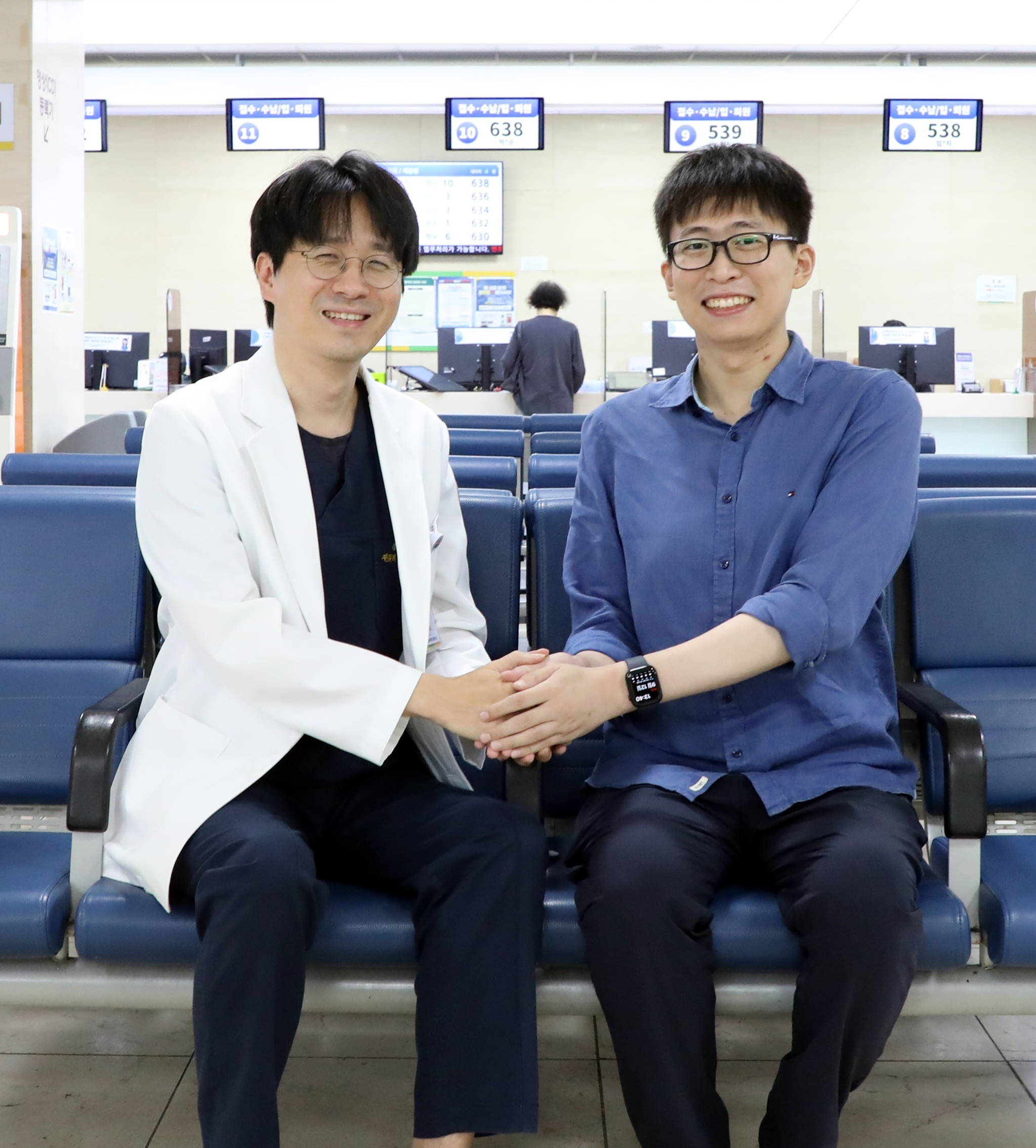 Emergency physician Prof. Cho Yong-su, left, holds hands with Kim Kwan-hang, who suffered cardiac arrest after being struck by lightning. [CHONNAM NATIONAL UNIVERSITY HOSPITAL]