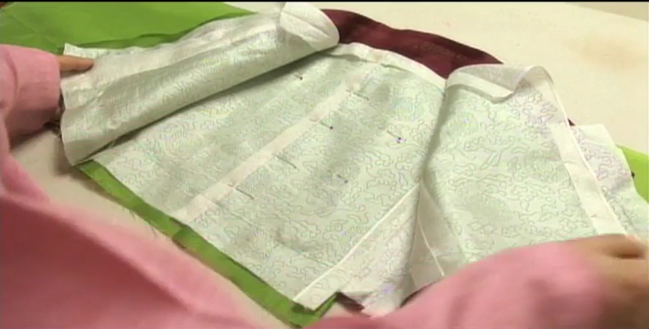 Hanbok, or traditional Korean dress, is made by planning in advance, and then cutting the fabrics and backstitching the linings and outer fabric together, as shown here. [SCREEN CAPTURE]