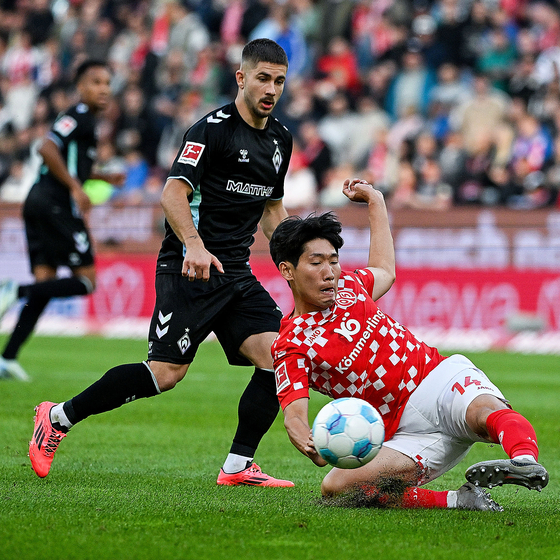 Hong Hyun-seok slides for a tackle during a Bundesliga match against Werder Bremen in Mainz, Germany on Sunday. [XINHUA/YONHAP]