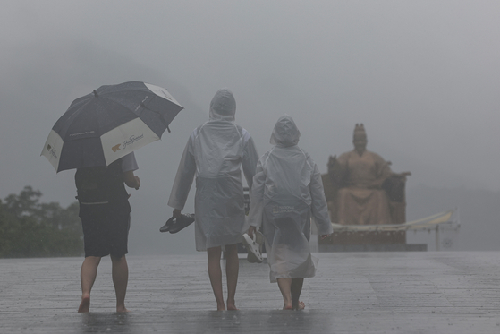 People walk in the monsoon rain in Gwanghwamun, central Seoul, on July 4, 2023 [YONHAP]