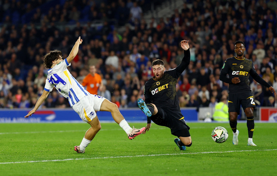 Brighton's Ferdi Kadioglu, left, scores a goal against Wolverhampton Wanderers during a third round Carabao Cup match on Wednesday at Falmer Stadium in England. [REUTERS/YONHAP] 