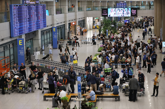 Travelers wait at Incheon International Airport's departure gates. [YONHAP]