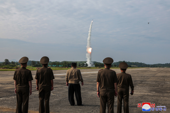 In this photo carried by North Korea's state-run Korean Central News Agency (KCNA), North Korean leader Kim Jong-un and officials look on as the Hwasongpho-11-Da-4.5, a new tactical ballistic missile, is test launched on Wednesday. [YONHAP]