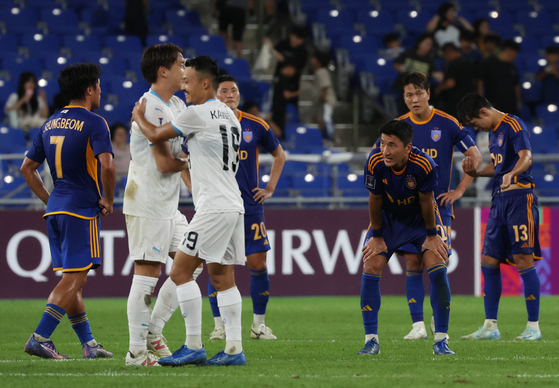 Ulsan HD, in blue, react after losing the 2024-25 AFC Champions League Elite match to Kawasaki Frontale at Munsu Football Stadium in Ulsan on Wednesday. [YONHAP]